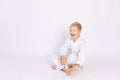 Judo and sports concept, blond boy sitting in kimono on white background, place for text Royalty Free Stock Photo