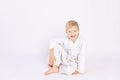 Judo and sports concept, blond boy sitting in kimono on white background, place for text Royalty Free Stock Photo