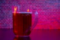 Jug of beer on a red lighting with brick background