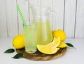 Jug with fresh lemon juice on a white wooden background. Royalty Free Stock Photo