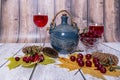 Jug, glass filled with red wine, vase with ripe cherries and yellow maple leaves lie on wooden table. Positive mood. Royalty Free Stock Photo