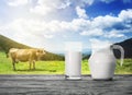 Jug and a glass of milk against a background of landscape with c Royalty Free Stock Photo