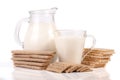 Jug and glass of milk with grain crispbreads isolated on white background Royalty Free Stock Photo