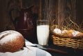 Jug and glass of milk on a wooden table basket with eggs and buckwheat bread Royalty Free Stock Photo