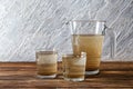 Jug and glasses with dirty water on wooden table Royalty Free Stock Photo