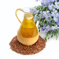 Jug with linseed oil, flax seeds and flowers isolated on white background Royalty Free Stock Photo