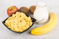 Jug of milk, bowl with corn flakes and fruits Royalty Free Stock Photo