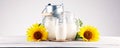 A jug of milk and glass of milk on a wooden table and flower