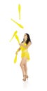 A juggler, a circus performer, a young woman in a yellow suit with dark hair, performs on a white background Royalty Free Stock Photo