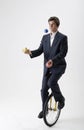 Juggling businessman on unicycle Royalty Free Stock Photo