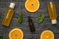 Juice bottles, vials with pipettes and orange slices on a wooden background