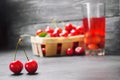 Juice or compote with cherries. fresh ripe red cherry in a basket on a gray concrete background, summer berry, summer drink