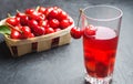 Juice or compote with cherries. fresh ripe red cherry in a basket on a gray concrete background, summer berry, space for text Royalty Free Stock Photo