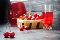 Juice or compote with cherries. fresh ripe red cherry in a basket on a gray concrete background, summer berry, space for text Royalty Free Stock Photo