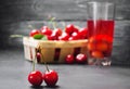 Juice or compote with cherries. fresh ripe red cherry in a basket on a gray concrete background, summer berry, summer drink Royalty Free Stock Photo