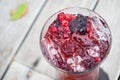 Juice mix berry fruit drink red purple color in tall glass on wooden Royalty Free Stock Photo