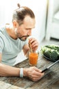 Focused unshaken man sitting and using the tablet. Royalty Free Stock Photo