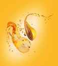 Juice splashes out from two halves of pear on a yellow background