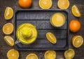 Juicer and a glass of juice with sliced oranges in a wooden tray wooden rustic background top view close up Royalty Free Stock Photo