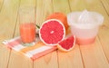 Juicer, grapefruit juice in glass, whole fruit and slices Royalty Free Stock Photo