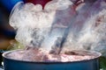 Juicy Angus steak frying in iron cast pan with smoke and Tongs on blurred nature background , cooking party picnic outdoor