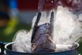 Juicy Angus steak frying in iron cast pan with smoke and Tongs on blurred nature background , cooking party picnic outdoor Royalty Free Stock Photo