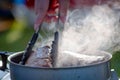 Juicy Angus steak frying in iron cast pan with smoke and Tongs on blurred nature background , cooking party picnic outdoor