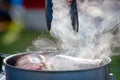 Juicy Angus steak frying in iron cast pan with smoke and Tongs on blurred nature background , cooking party picnic outdoor