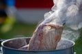 Juicy Angus steak frying in iron cast pan with smoke and Tongs on blurred nature background , cooking party picnic outdoor