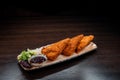 Juicy appetizing fried chicken nuggets in cheesecake with barbecue sauce decorated with greens on a plate in a restaurant. Royalty Free Stock Photo