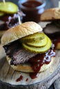 Juicy barbecue brisket sandwich with pickles and sauce on rustic board Royalty Free Stock Photo