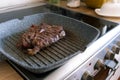 Juicy beef meat steak cooking on griddle pan at professional kitchen. Prime steak frying at grill. Delicious, modern Royalty Free Stock Photo