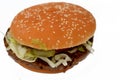 A juicy beef patty with cheese covered with sauce, crispy lettuce, fresh tomatoes, onions and pickles in a large sesame seed bun, Royalty Free Stock Photo