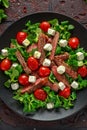 Juicy Beef Sirloin Steak Salad with roasted tomatoes, feta cheese and green vegetables in a black plate. healthy food Royalty Free Stock Photo