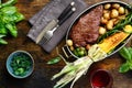 Juicy beef steak in frying pan with vegetables and red wine Royalty Free Stock Photo