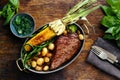 Juicy beef steak in frying pan with vegetables top view Royalty Free Stock Photo