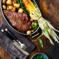 Juicy beef steak in frying pan with vegetables top view Royalty Free Stock Photo