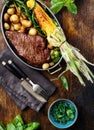 Juicy beef steak in frying pan with vegetables top view Royalty Free Stock Photo