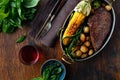 Juicy beef steak in frying pan with vegetables and red wine Royalty Free Stock Photo