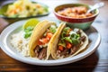 juicy beef tacos with a side of refried beans and rice