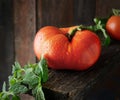 Juicy big tomato with herbs on dark wooden background Royalty Free Stock Photo