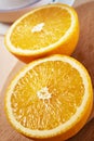 Juicy bisected oranges closeup on wooden board vertical