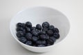 Juicy blackberries in a white bowl, berries in a white plate on a white background