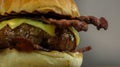 Juicy cheeseburger with crispy bacon in grilled brioche buns close up