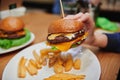 Juicy cheeseburger in girls hand.