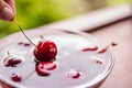 Juicy cherry in the beautiful female hand isolated on blurred background, with clipping path.Cherries in glass bowl Royalty Free Stock Photo