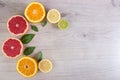 Juicy citrus fruits cut background mint leaf. Oranges, lemons, limes, grapefruit, mint leaves on a bright wooden background