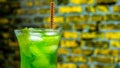 Juicy cold green lemonade in a glass on a brick wall background. The cocktail is green Royalty Free Stock Photo