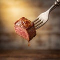 A juicy cube of steak speared on a silver fork. Royalty Free Stock Photo