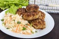 Juicy cutlets and salad with fresh vegetables: cabbage, carrots, greens Royalty Free Stock Photo